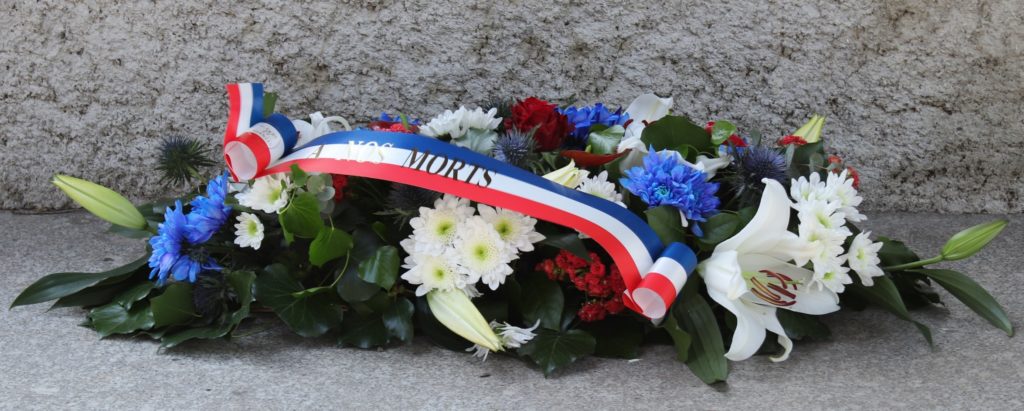 Gerbe de fleur déposée au pied du monument aux morts